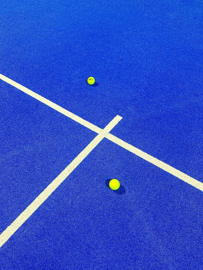 two tennis balls on a blue tennis court